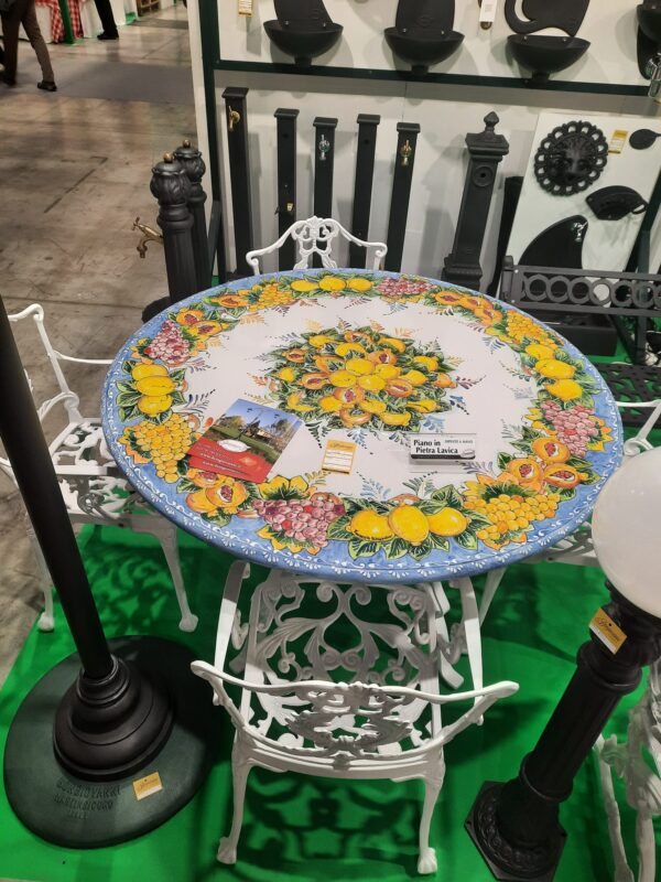 Piano in pietra lavica dipinto a mano con sedie in mostra all'Artigiano in Fiera 2024 Milano Rho Fiera